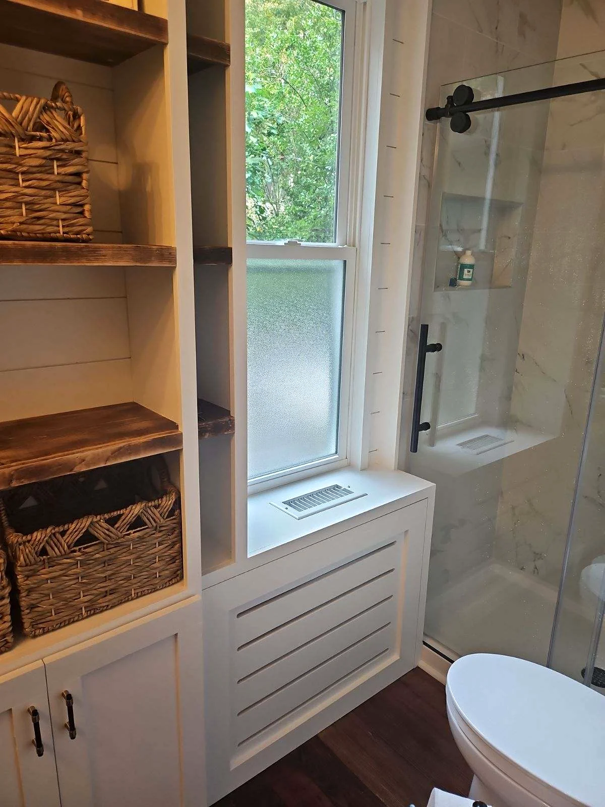 Custom bathroom storage beside glass shower
