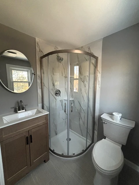 Compact bathroom remodel with corner glass shower